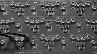 Nahaufnahme einer Platine mit elektrischen Schaltungen, Bauteilen und LEDs für topolektrische Forschung.